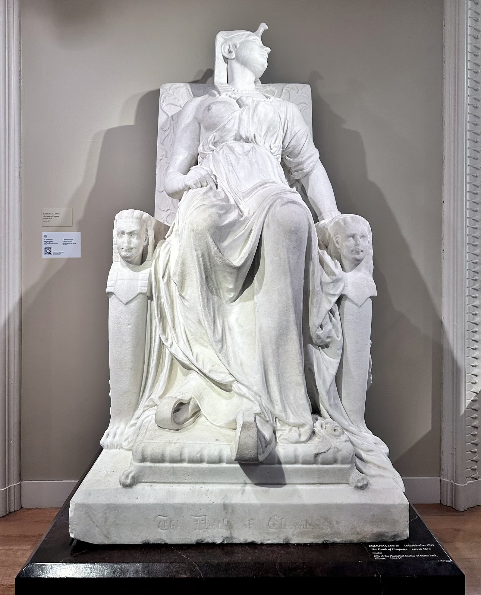 La Mort de Cléopâtre d'Edmonia Lewis : figure de marbre blanche affaissée sur un trône
