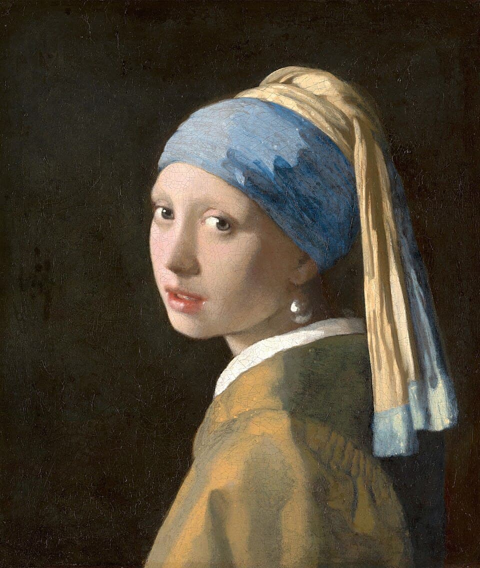 La Jeune Fille à la perle de Vermeer : une jeune femme au turban bleu et jaune se retourne vers le spectateur, bouche entrouverte, une perle scintille à son oreille sur fond sombre.